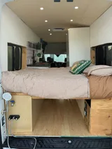 Bed setup inside Ford Transit camper van rental in Lakewood California