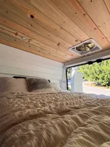 Bed setup inside Wanderful Wheels HoneyVroom camper van rental in Bellevue Washington