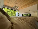 Bed setup inside Wanderful Wheels HoneyVroom camper van rental in Bellevue Washington