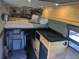 Bed setup inside Navan Vans Guinevere camper van rental in Bellevue Washington