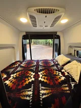 Bed setup inside Tiffin GH1 camper van rental in Bellevue Washington